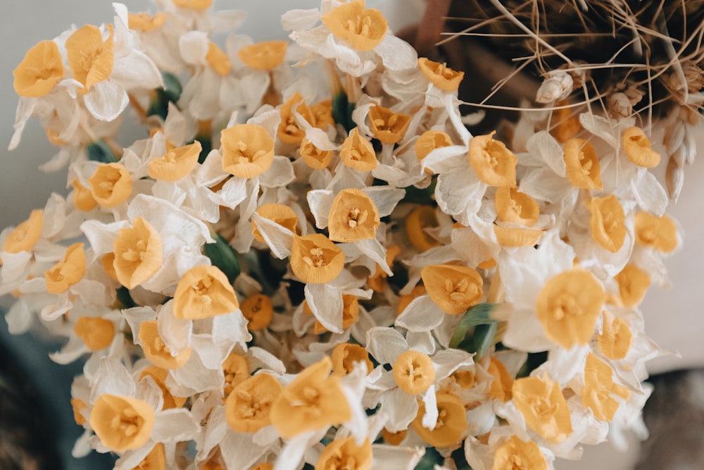 a bunch of yellow and white flowers in a vase