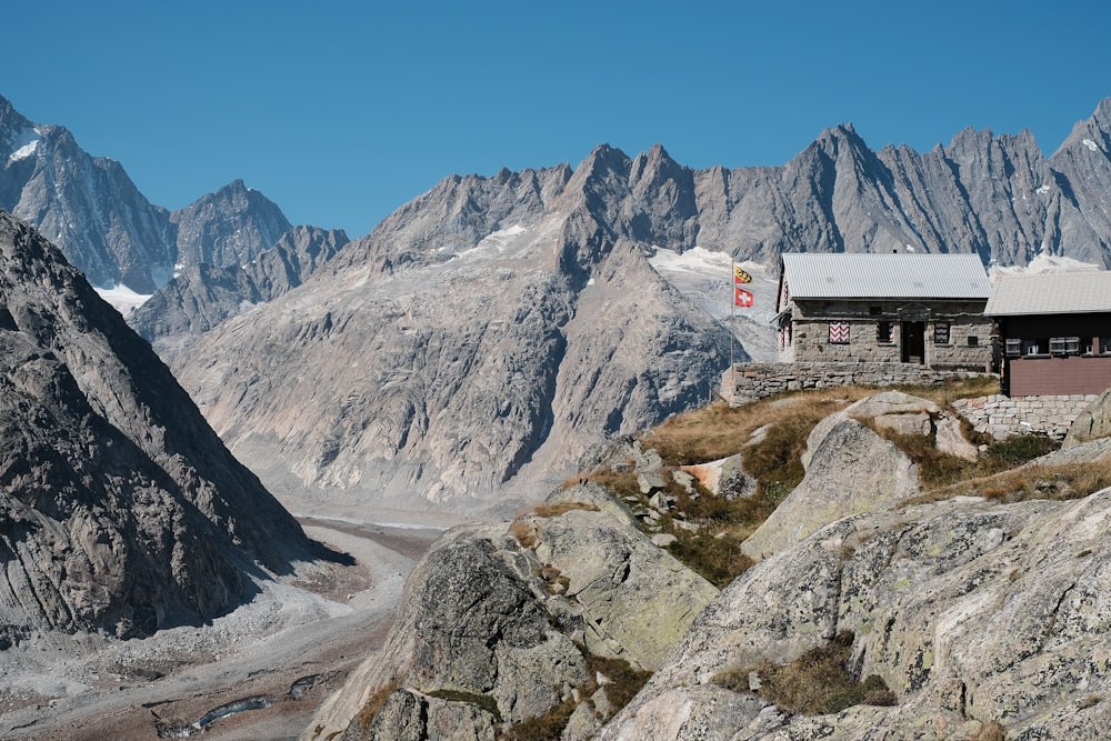 a cabin on a mountain with a glacier in the background