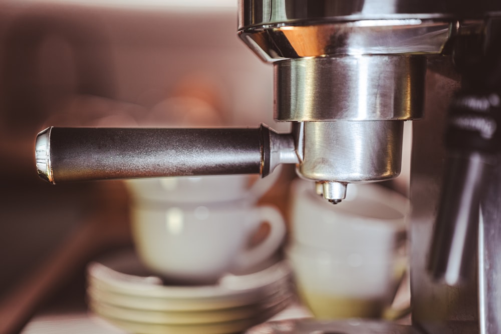 a close up of a coffee maker with cups