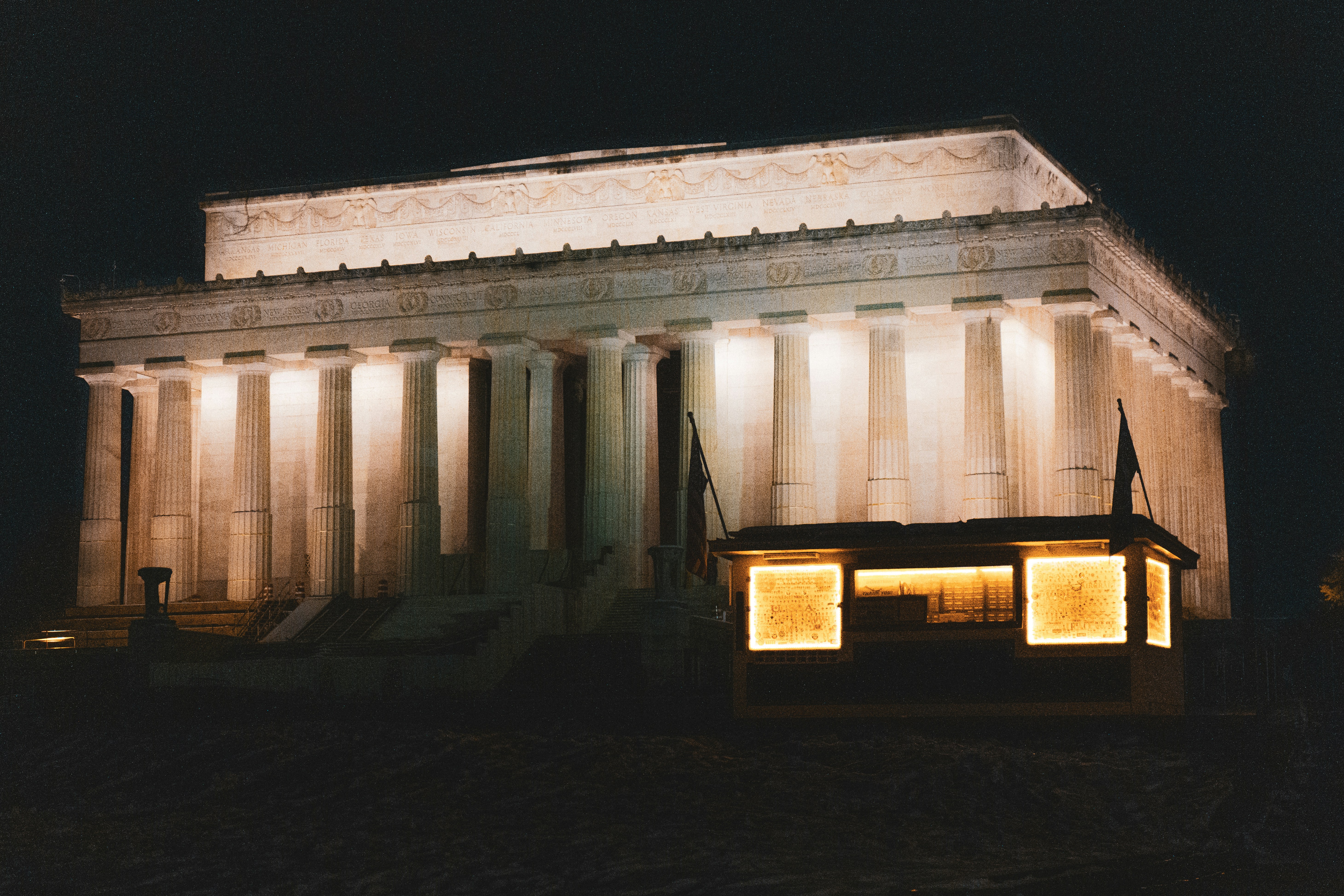 a building with columns and lights on it at night