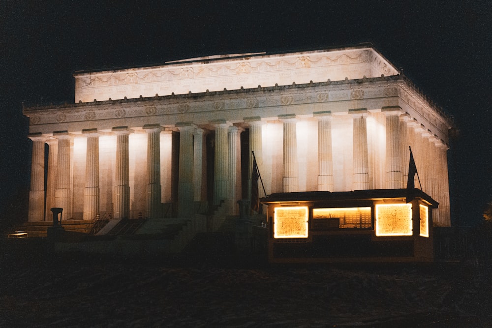 a building with columns and lights on it at night