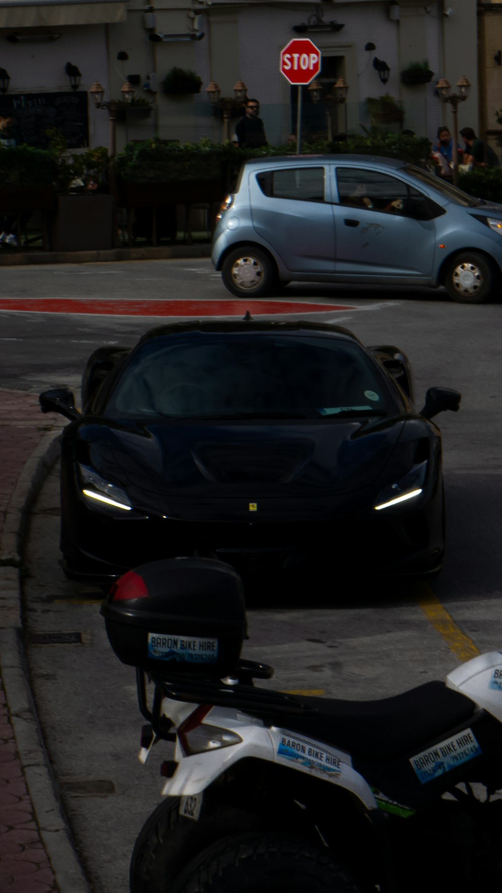 a motorcycle parked on the side of a road next to a car