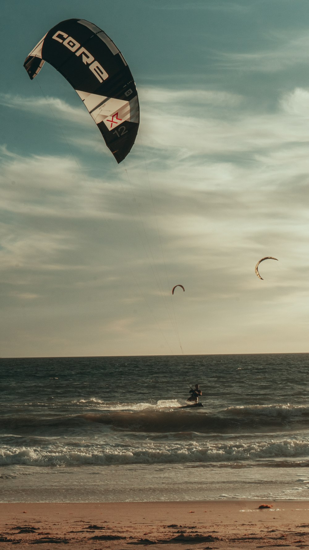 a person parasailing on the beach at sunset