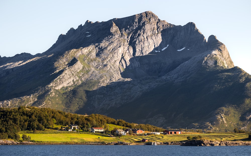 a large mountain with a house in the foreground