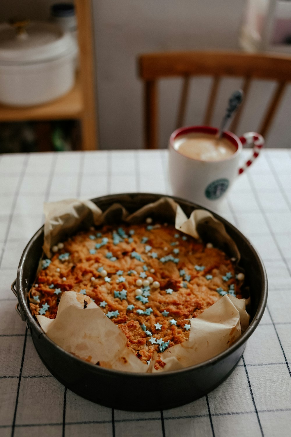 una sartén llena de pastel junto a una taza de café