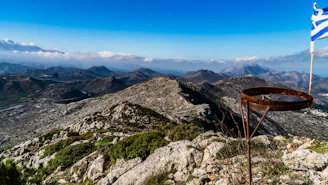 a greek flag on top of a mountain