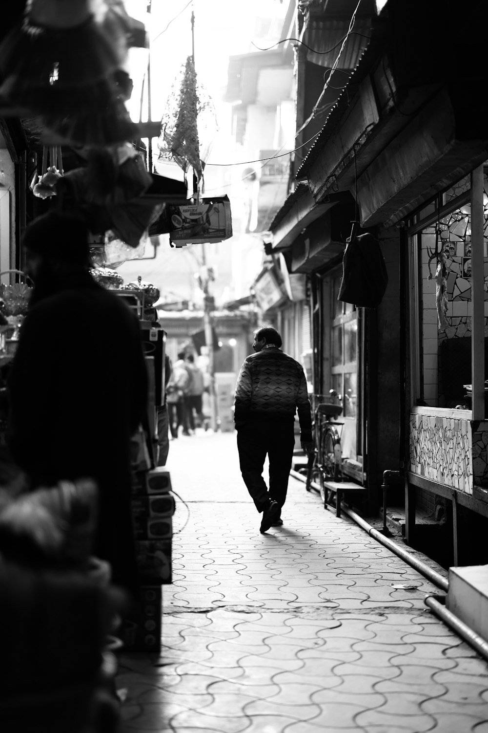 a black and white photo of a man walking down a street