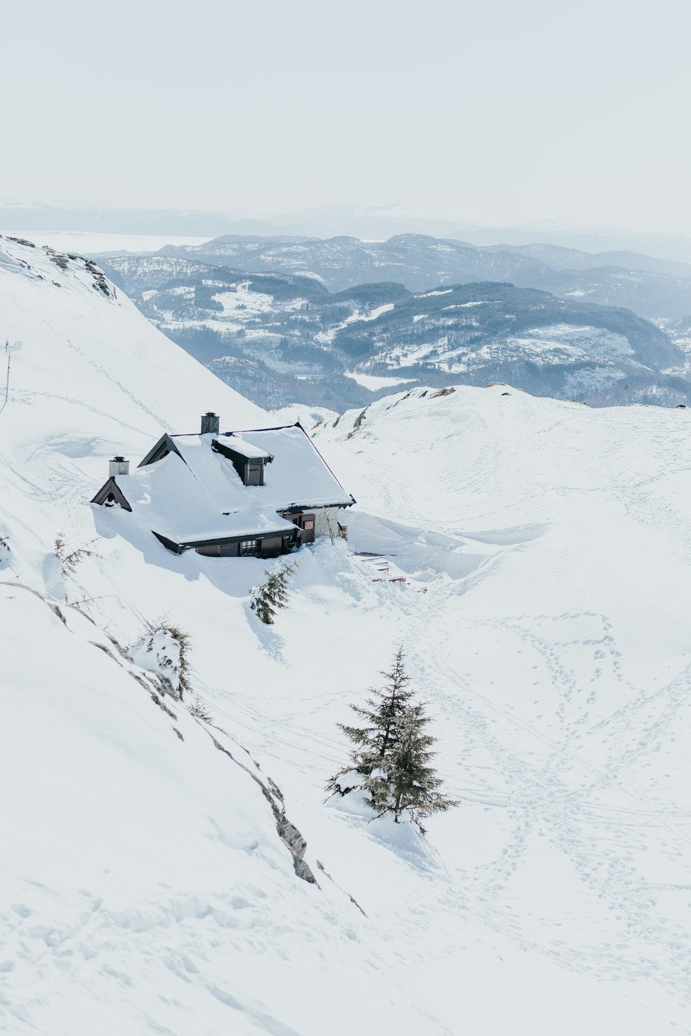 a snow covered mountain with a house on top of it