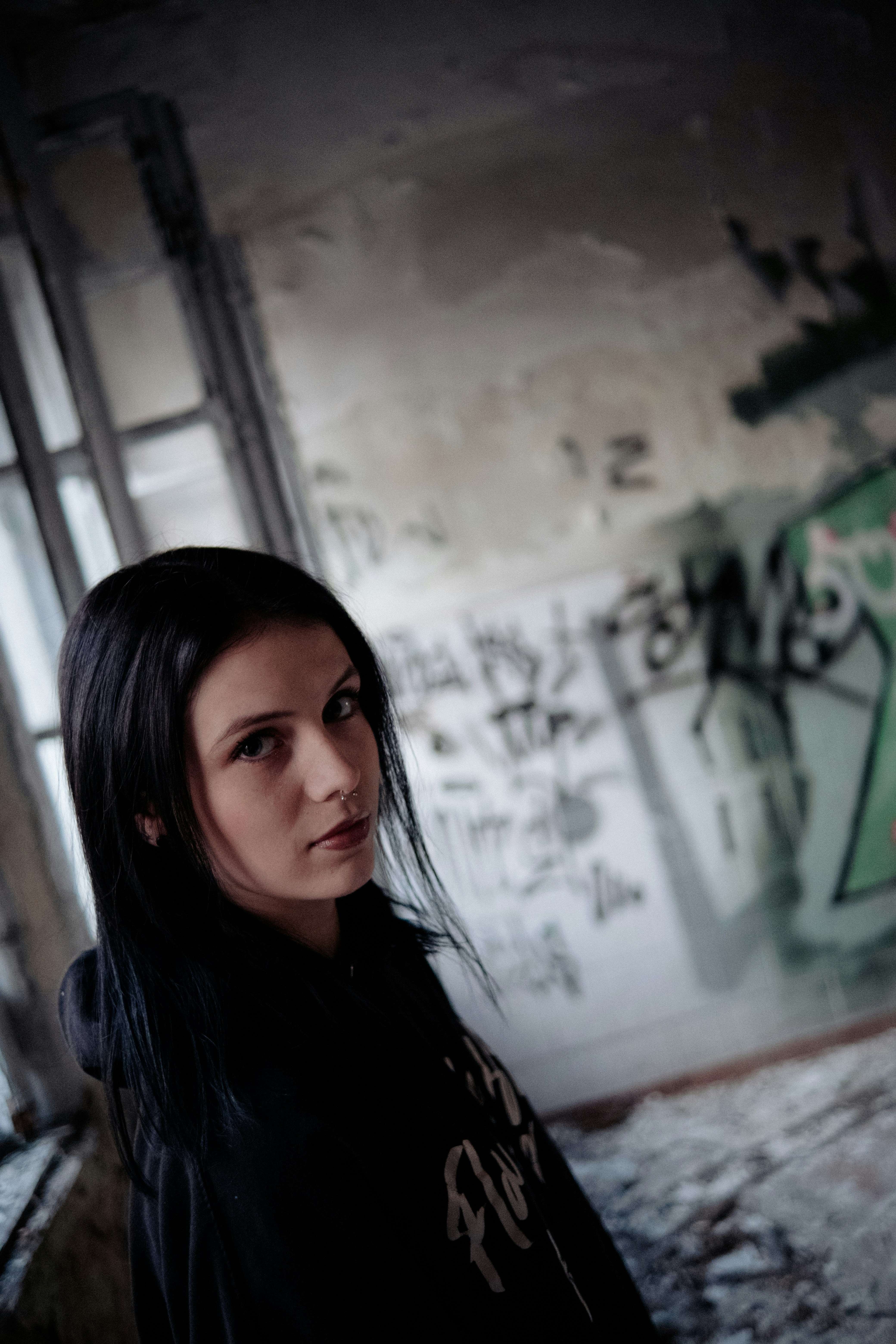 a woman standing in a room with graffiti on the walls