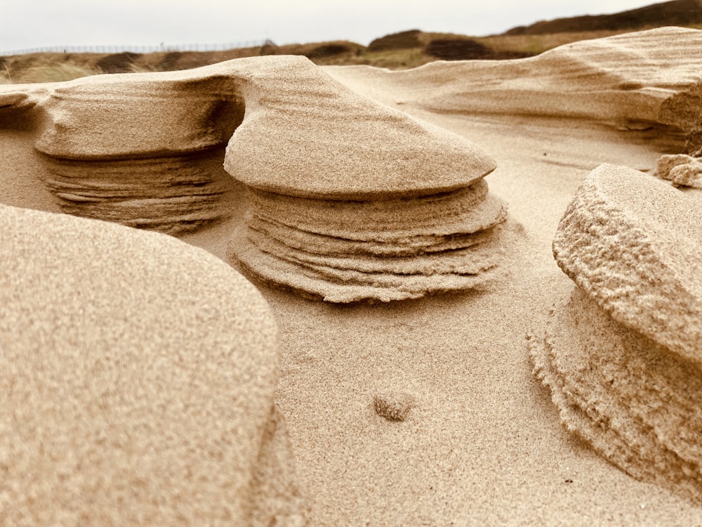 a pile of rocks sitting on top of a sandy beach