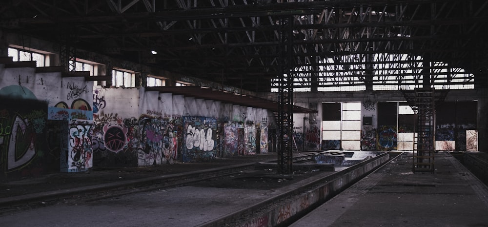 an abandoned train station with graffiti on the walls