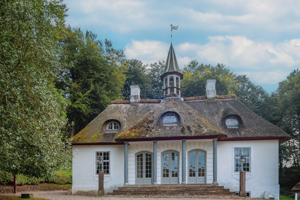 ein weißes Gebäude mit einem Kirchturm und einem Glockenturm