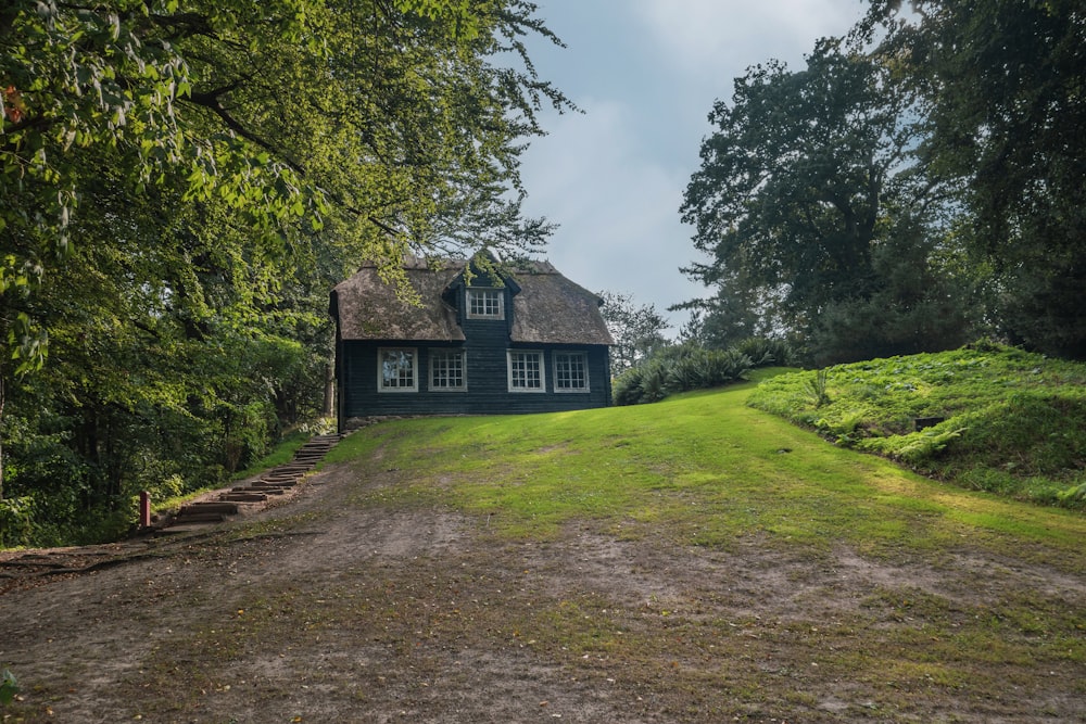 a green house sitting on top of a lush green hillside