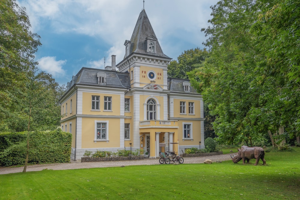 un cheval debout devant un grand bâtiment jaune