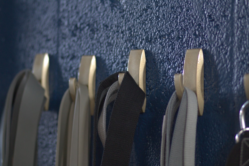 a row of metal hooks on a blue wall