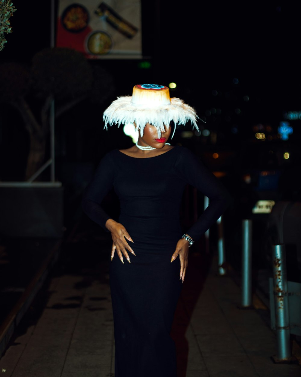 a woman in a black dress and a white feather hat