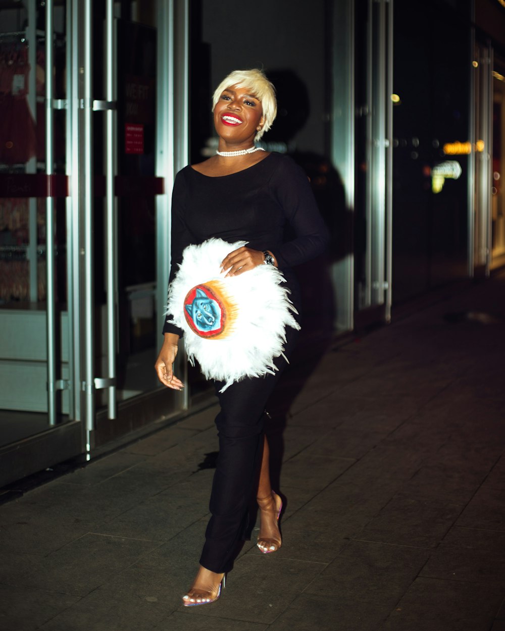 a woman in a black top and white feather skirt