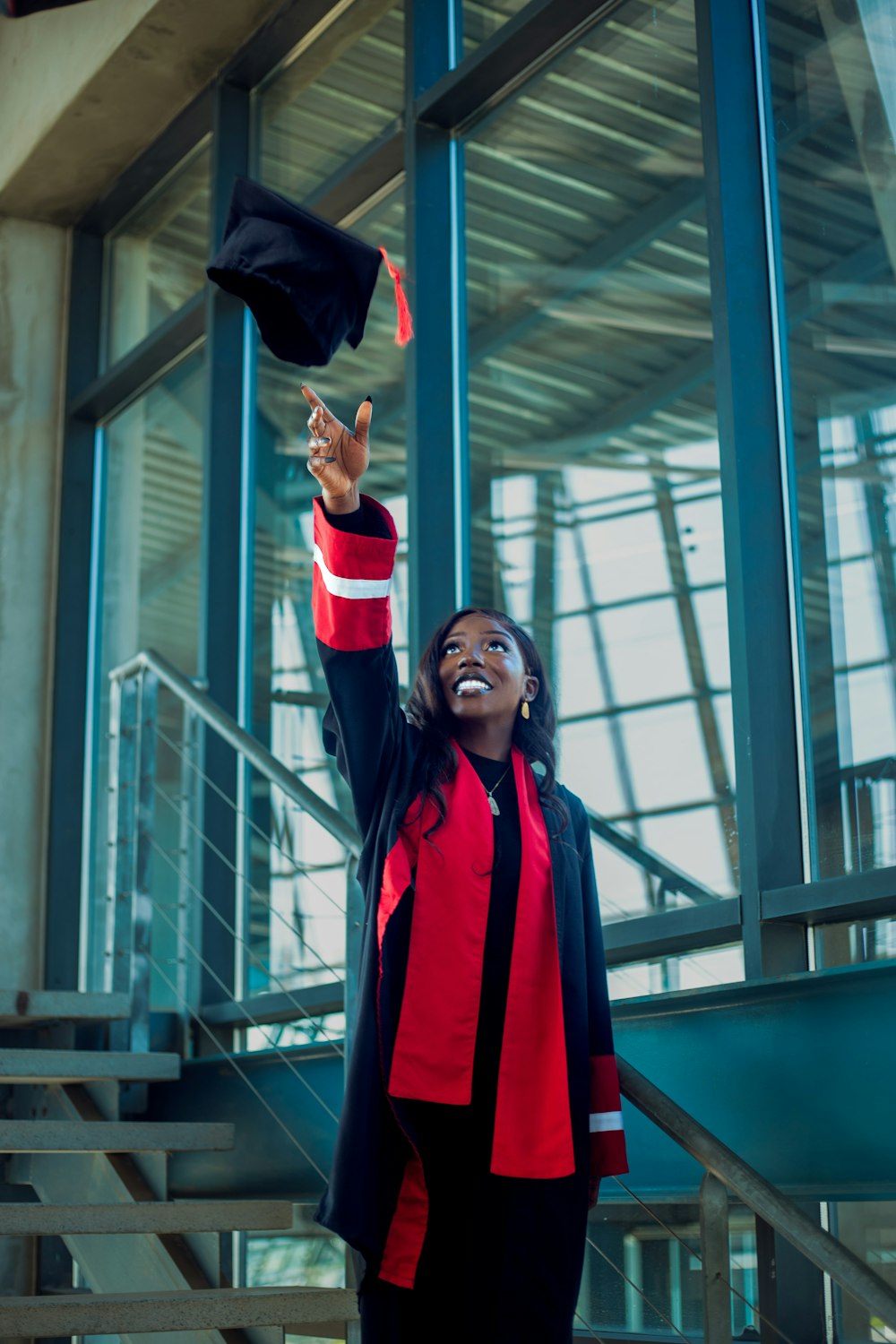 a woman in a red and black graduation outfit