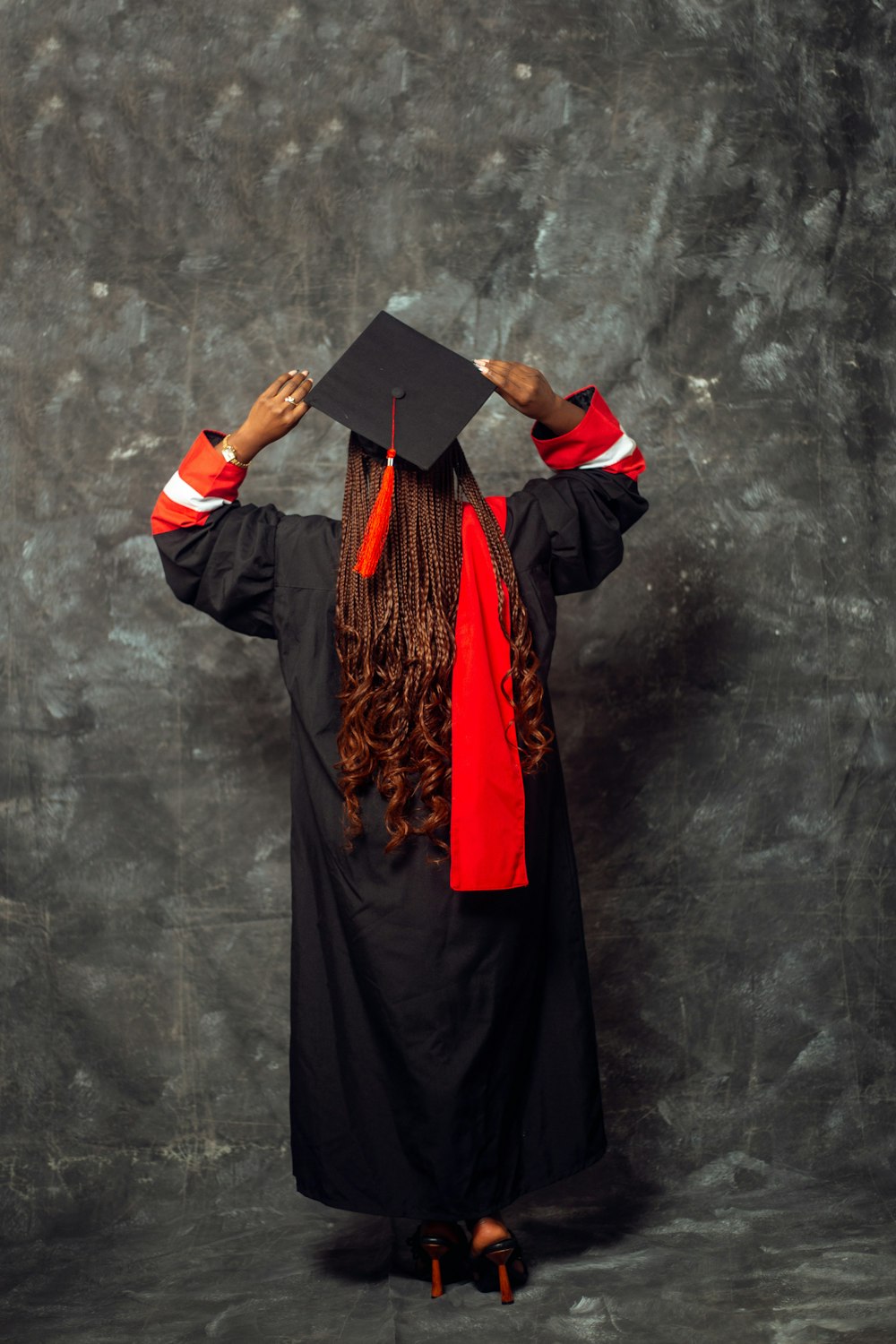 una mujer con un vestido de graduación y un sombrero negro