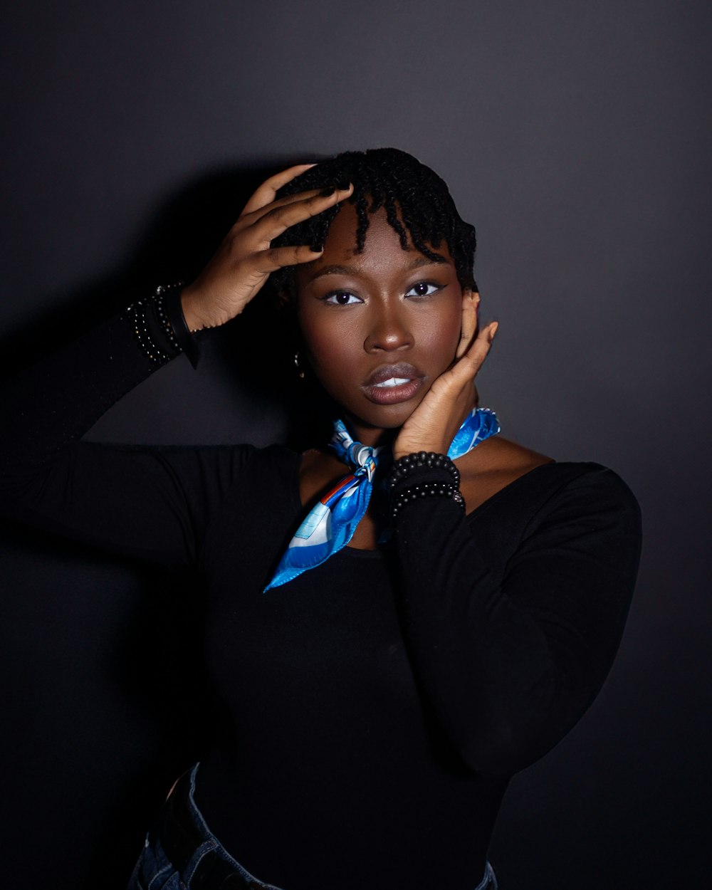 a woman in a black shirt and a blue scarf