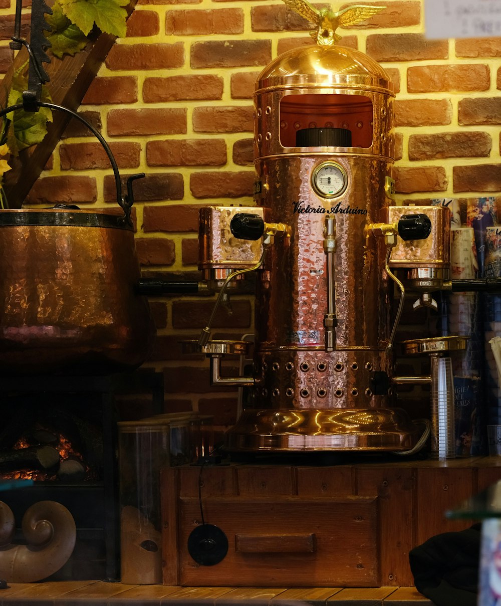 a copper colored machine sitting on top of a wooden table