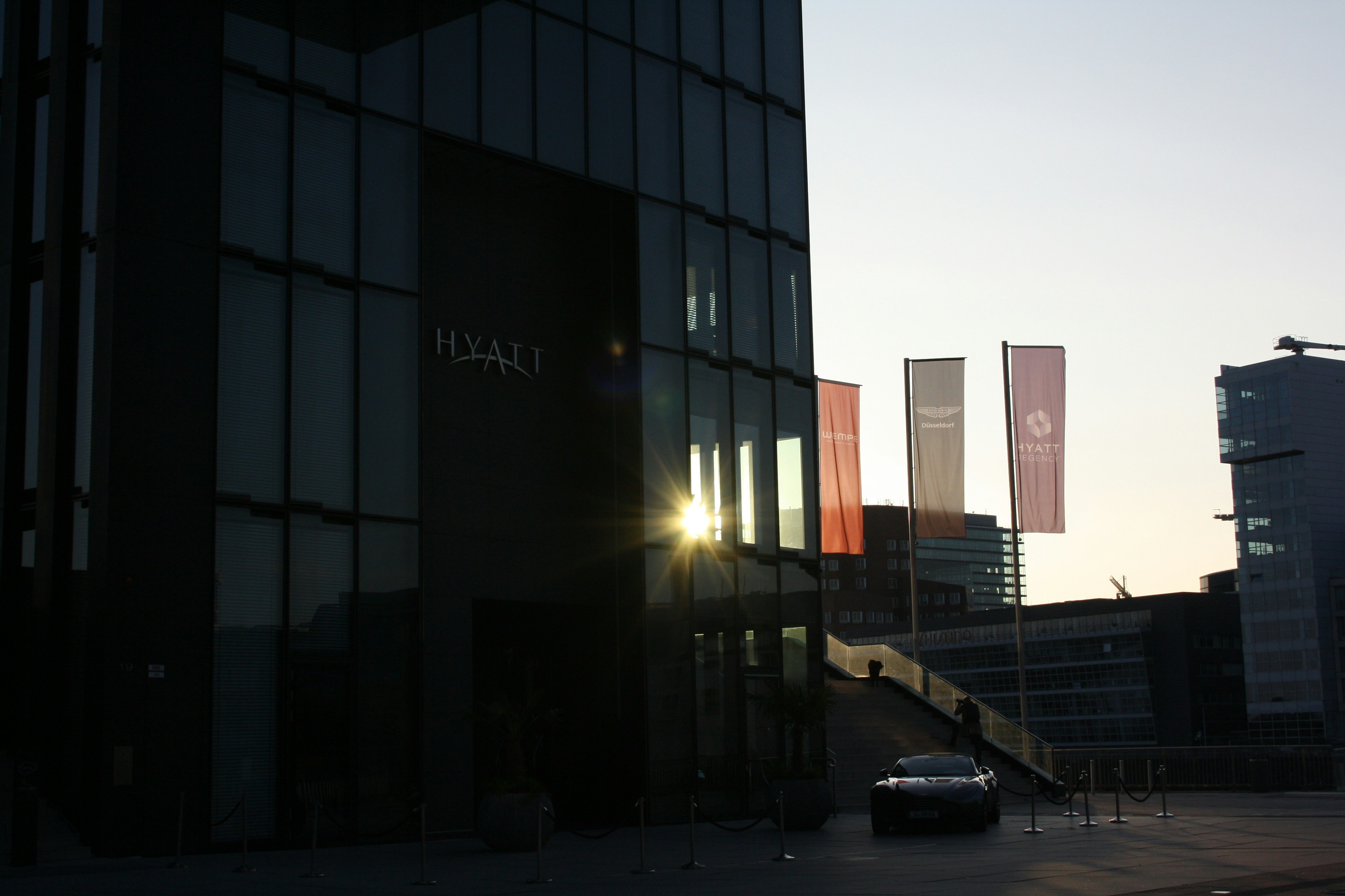 a car is parked in front of a tall building