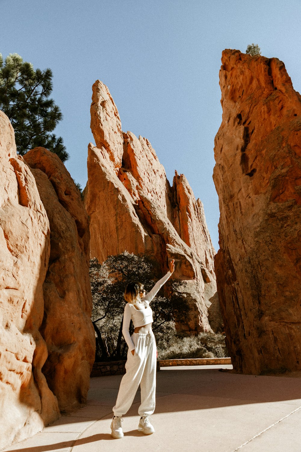a woman standing in front of a rock formation