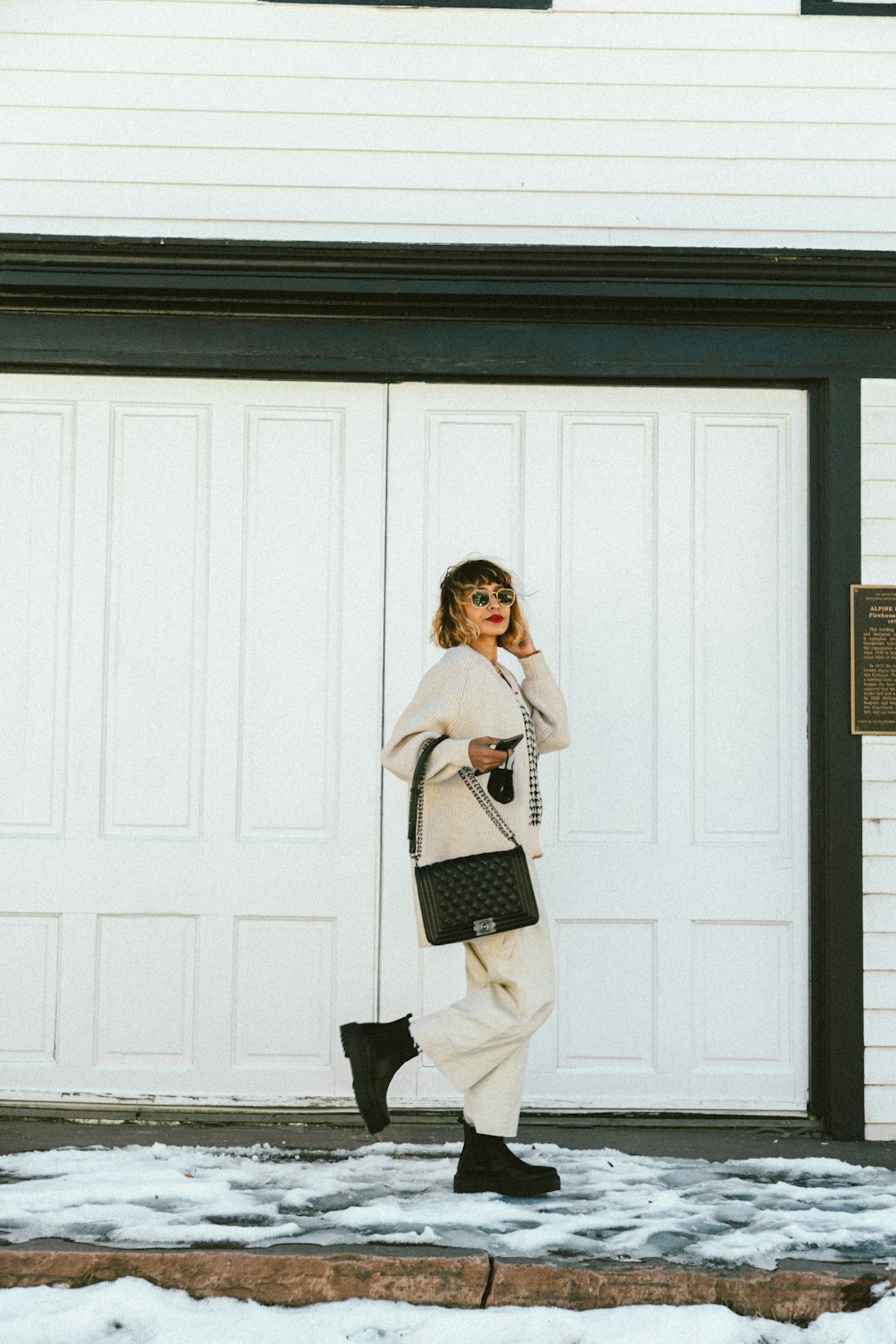 a woman is walking in front of a garage door