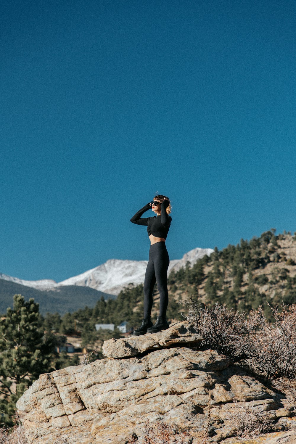 a woman standing on top of a rocky hill