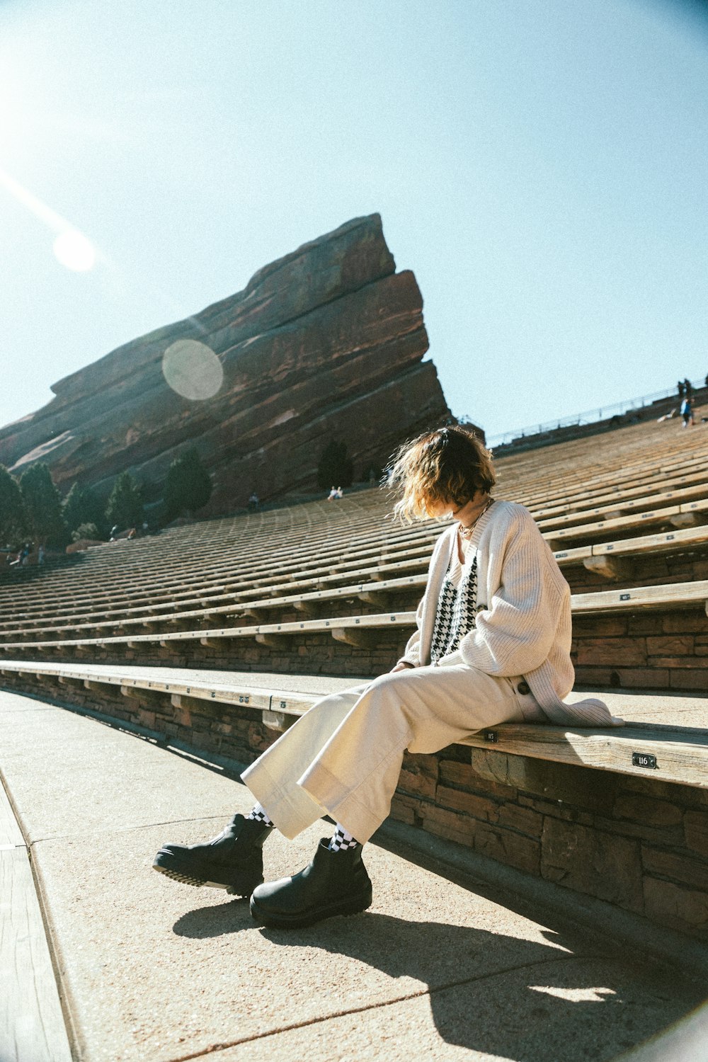 a person sitting on a ledge in a stadium