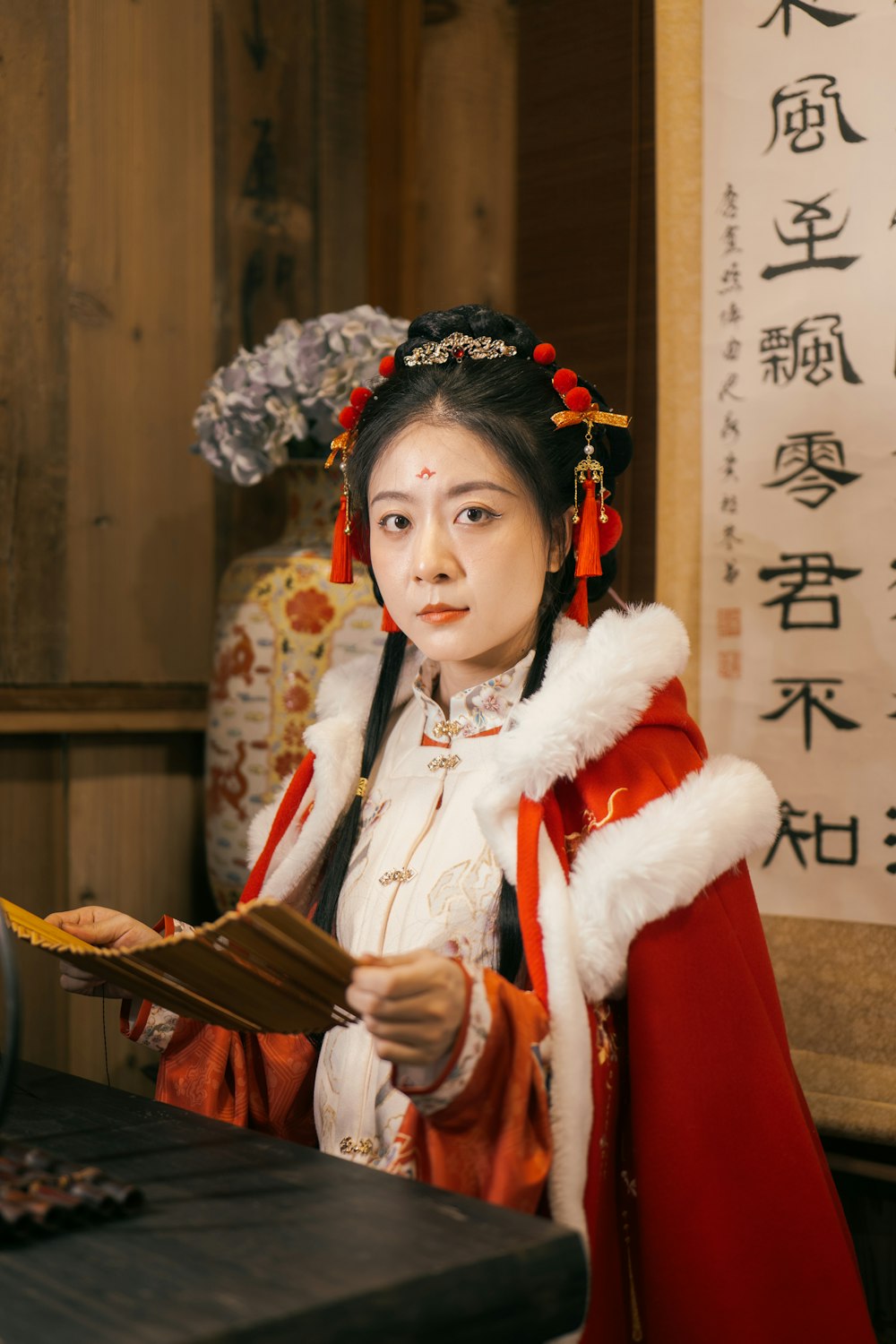 a woman dressed in a chinese costume holding a piece of paper