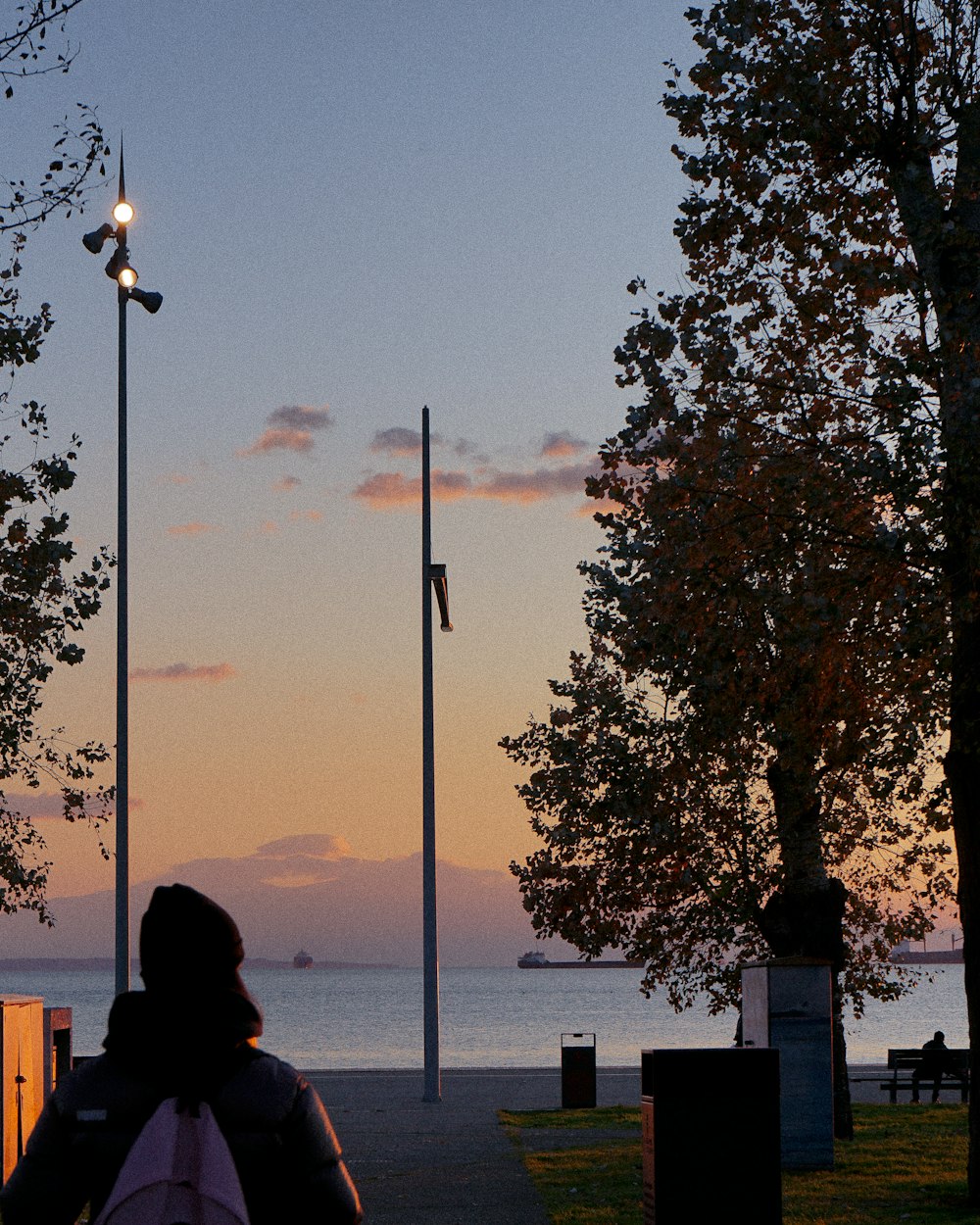 a person sitting on a bench in front of a body of water