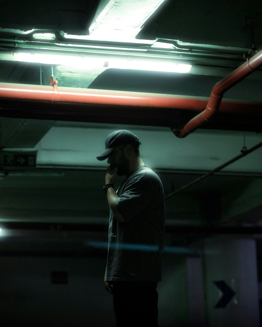 a man standing in a parking garage talking on a cell phone