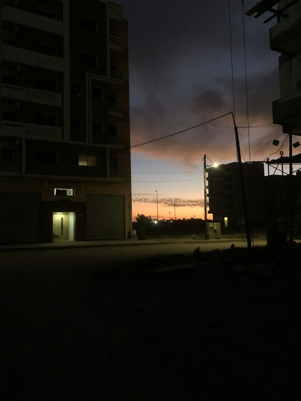 a dark city street at night with a building in the background