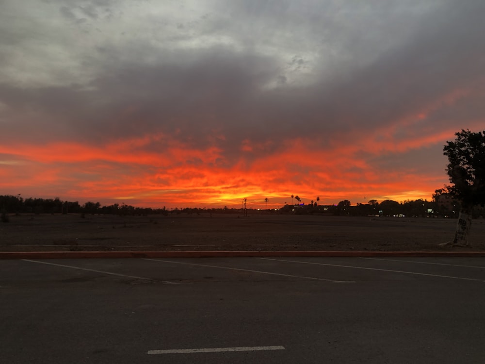 the sun is setting over a parking lot