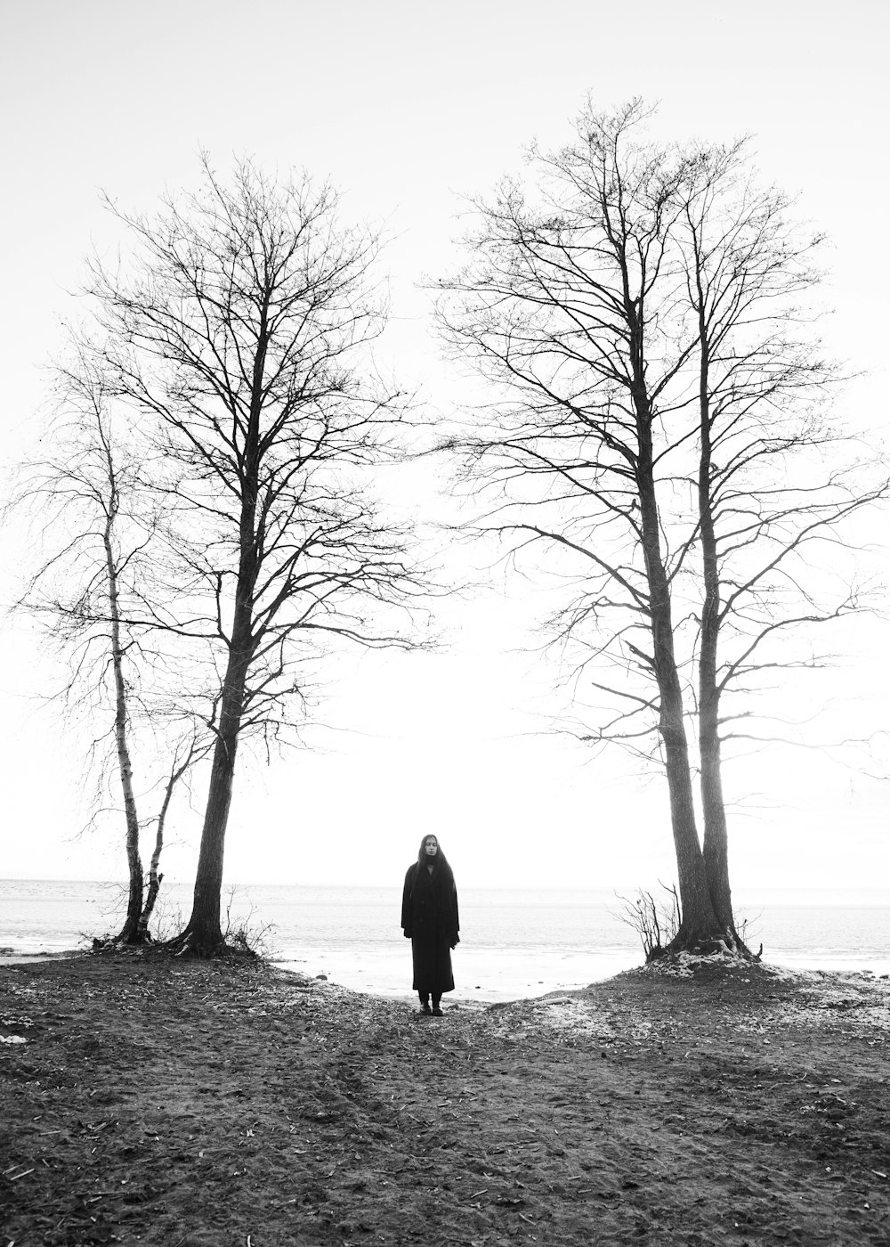 una persona in piedi davanti ad alcuni alberi