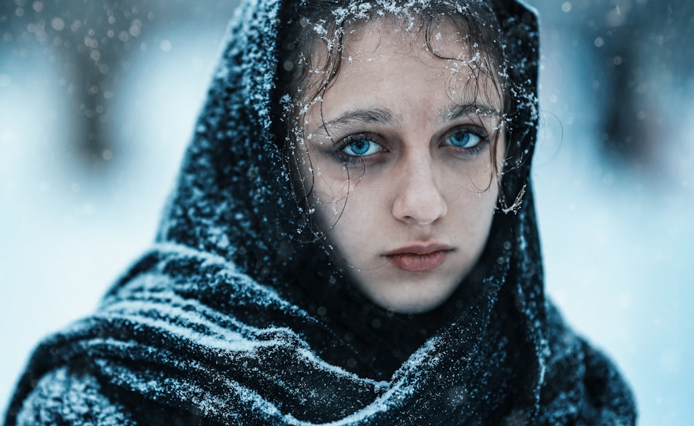 a woman with blue eyes is covered in snow