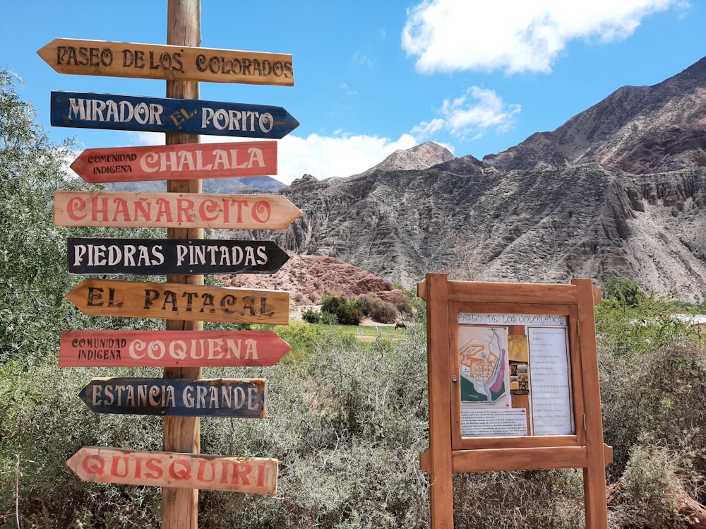 a wooden sign with many different signs on it