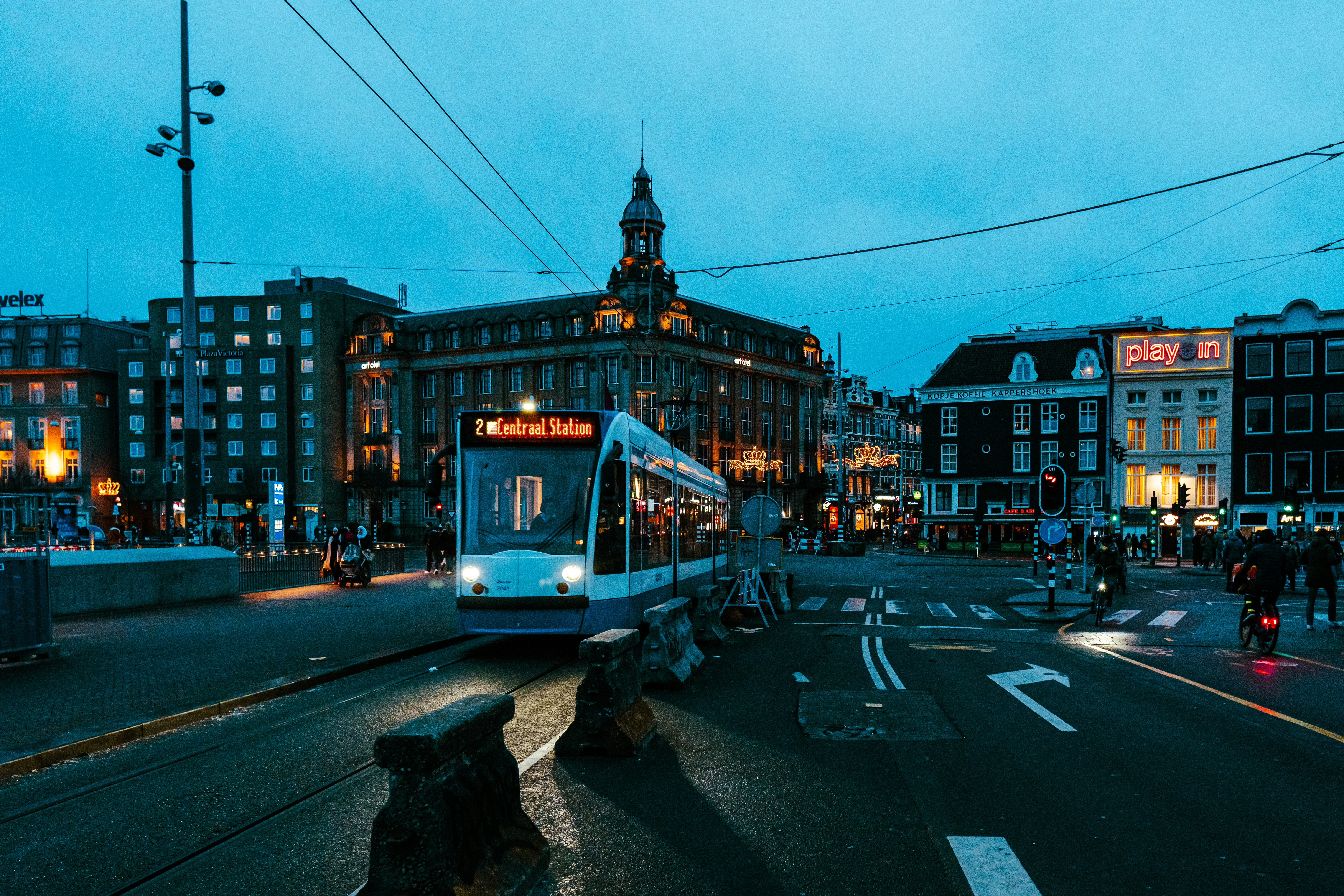 a train traveling down a street next to tall buildings