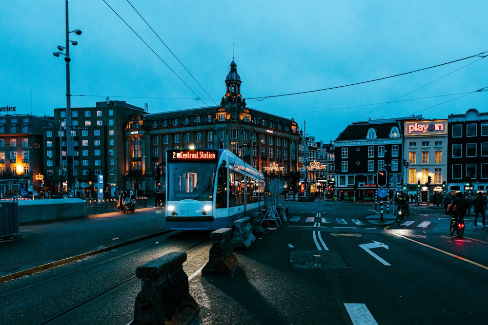 a train traveling down a street next to tall buildings