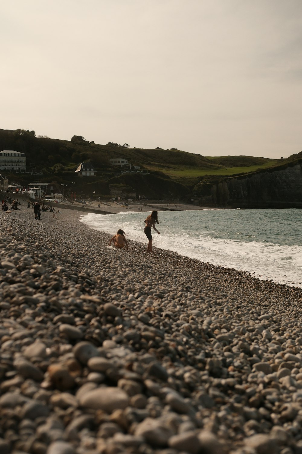 a group of people walking along a beach next to the ocean