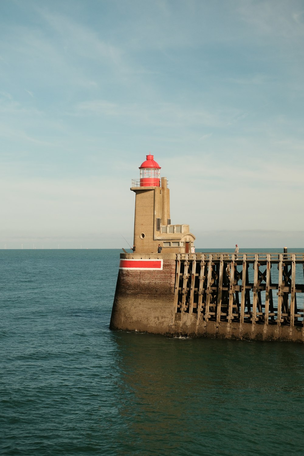 a light house sitting on top of a pier next to the ocean