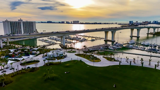 an aerial view of a marina with a bridge in the background