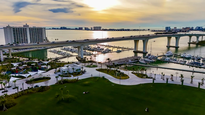 an aerial view of a marina with a bridge in the background