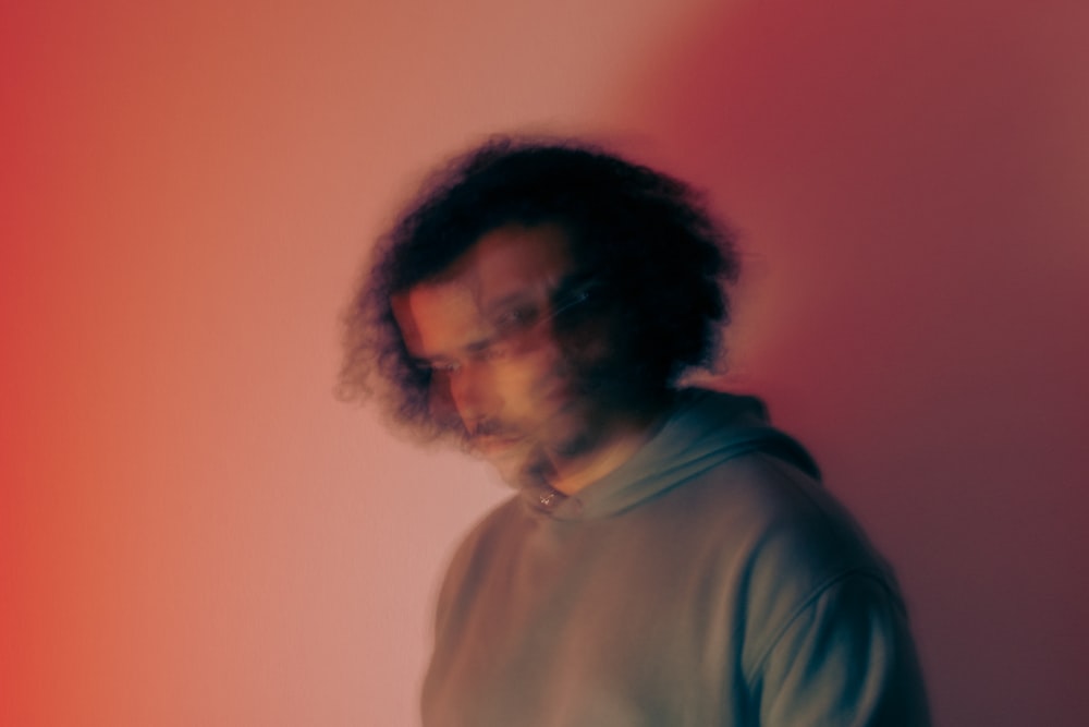 a man standing in front of a red wall