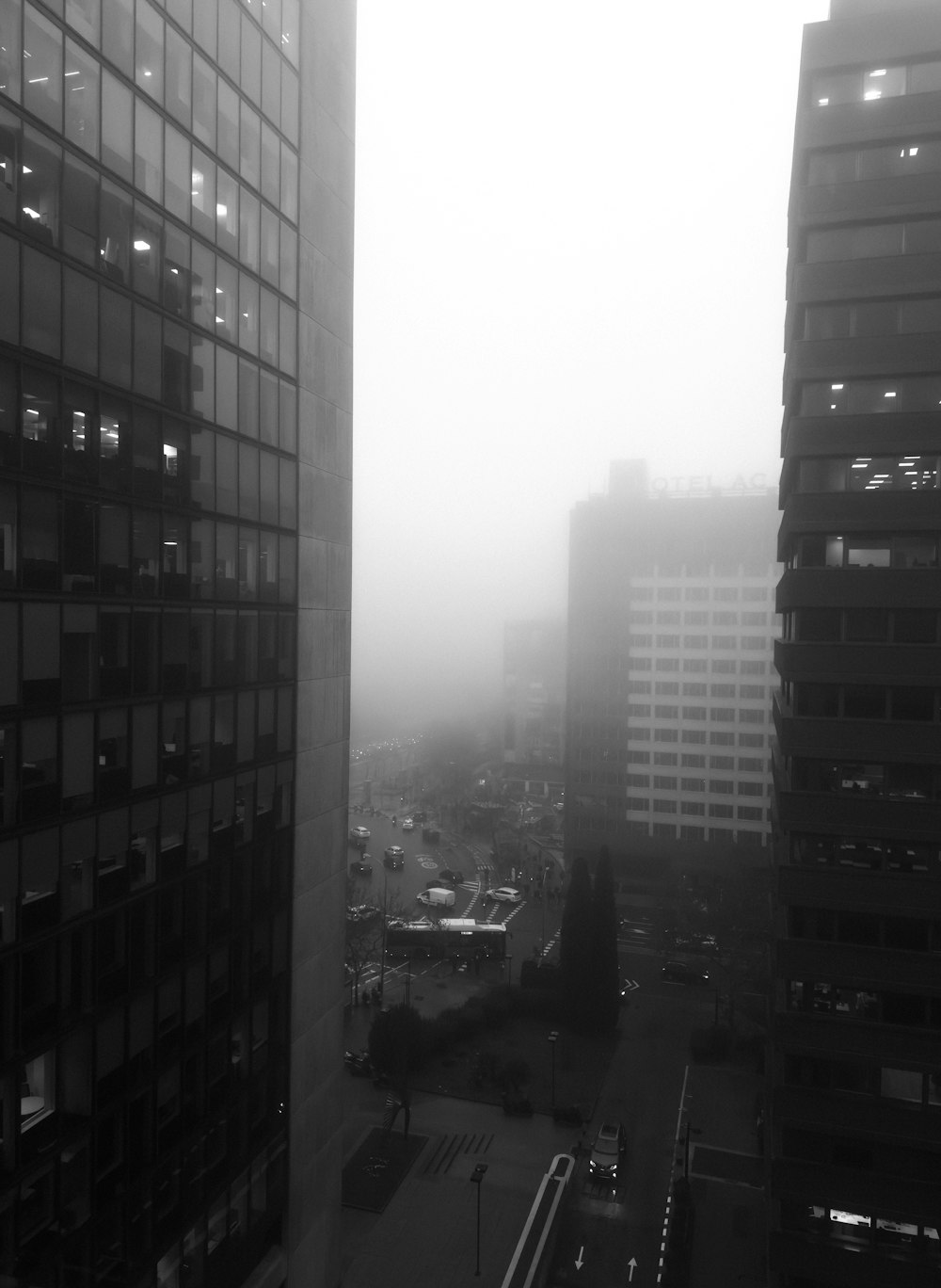 a black and white photo of a city in the fog