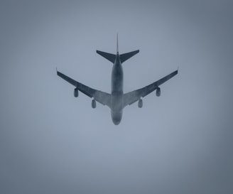 a large jetliner flying through a foggy sky