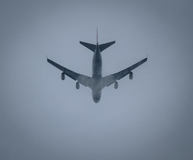 a large jetliner flying through a foggy sky