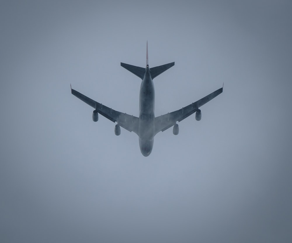 a large jetliner flying through a foggy sky