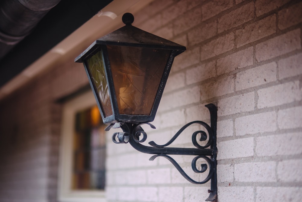 a lamp on the side of a brick building